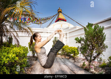 Donna fare yoga nei pressi di Bodnath stupa, Kathmandu, Nepal Foto Stock