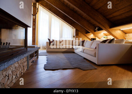 Prestigioso hotel di lusso Alpine soggiorno con moderno angolo divano bianco e camino Foto Stock