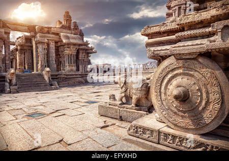 Carro di pietra nel cortile del tempio Vittala al tramonto cielo nuvoloso in Hampi, Karnataka, India Foto Stock