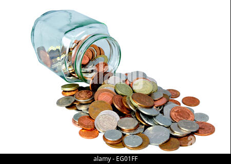 Tagliare fuori il vasetto di vetro pieno di Regno Unito British monete spargimento su sfondo bianco Foto Stock