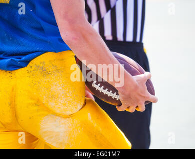 Sono arbitro e giocatore di football americano tenendo la palla nelle sue mani Foto Stock