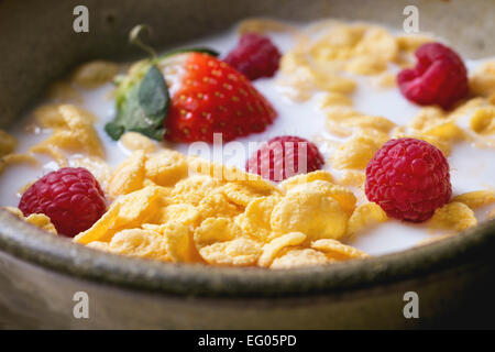 Cornflakes con latte e frutti di bosco in vaso in ceramica Foto Stock