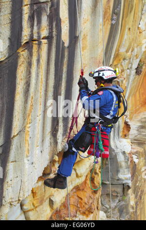 Un elemento maschio della speciale team operazioni all'interno del servizio ambulanza del NSW, conduce la discesa in corda doppia e rappelling formazione. Foto Stock