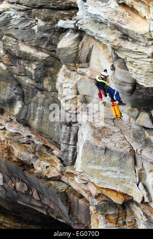 Un elemento maschio della speciale team operazioni all'interno del servizio ambulanza del NSW, conduce la discesa in corda doppia e rappelling formazione. Foto Stock