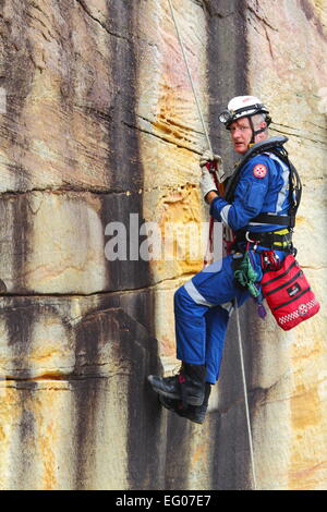 Un maschio di membri della speciale team operazioni all'interno del servizio ambulanza del NSW, condurre la discesa in corda doppia e rappelling formazione. Foto Stock