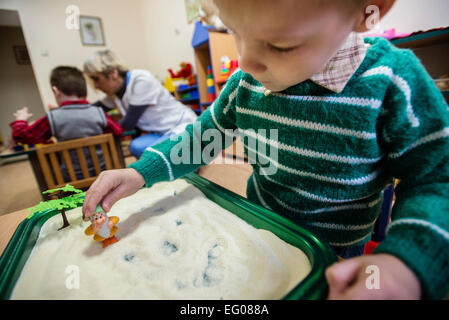 Ragazzo gioca con i giocattoli in camera di Montessori istruzione, orfanotrofio "Zhytomyr regionali di bambini a casa', Ucraina. 2 febbraio 2015. "Zhytomyr regionali di casa dei bambini' ha 67 bambini orfani da neonati a 4 anni di età. 25% di loro hanno mentale, disabilità intellettuale, HIV. Orfanotrofio ha più di 90% di adozione. Sin dal 2008 anno Ucraina fornendo programma di smantellamento orfanotrofio governativa, incluso il "Zhytomyr regionali di casa dei bambini". Foto di Oleksandr Rupeta Foto Stock