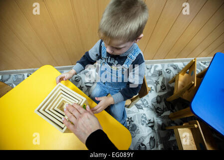 Ragazzo orfano gioca con lo sviluppo del giocattolo, orfanotrofio "Zhytomyr regionali di bambini a casa', Ucraina. 2 febbraio 2015. "Zhytomyr regionali di casa dei bambini' ha 67 bambini orfani da neonati a 4 anni di età. 25% di loro hanno mentale, disabilità intellettuale, HIV. Orfanotrofio ha più di 90% di adozione. Sin dal 2008 anno Ucraina fornendo programma di smantellamento orfanotrofio governativa, incluso il "Zhytomyr regionali di casa dei bambini". Foto di Oleksandr Rupeta Foto Stock