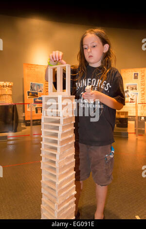 Ragazzo costruisce la torre Keva con tavole di legno al mondo della scienza, Vancouver, British Columbia, Canada (modello rilasciato) Foto Stock