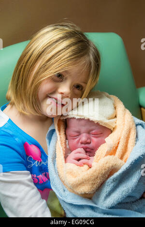 Ragazza giovane detiene il nuovo bambino fratello Foto Stock