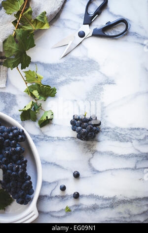 Uva nera su un piano di marmo Foto Stock