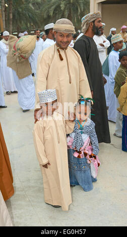 Un orgoglioso Omani padre con i suoi due figli piccoli, tutti perfettamente vestito in abiti tradizionali a Muscat in Oman. Foto Stock