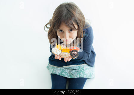 Ritratto di una ragazza che tiene tre saggi biscotti di Natale Foto Stock