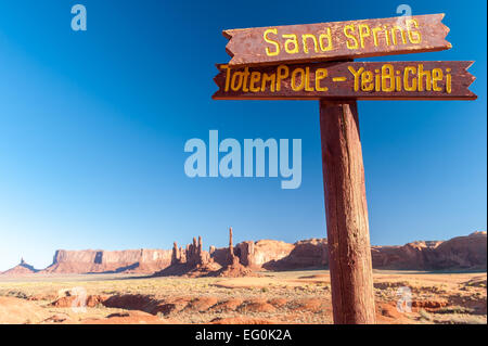 Cartello in legno di fronte alle formazioni rocciose Sand Spring e Totem Pole, Monument Valley, Arizona Utah Border, USA Foto Stock