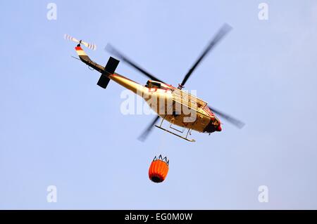 Bell 412 elicottero (registrazione N167EH) che trasportano acqua per la lotta antincendio, Cabopino Golf, Costa del Sol, provincia di Malaga, Andal Foto Stock