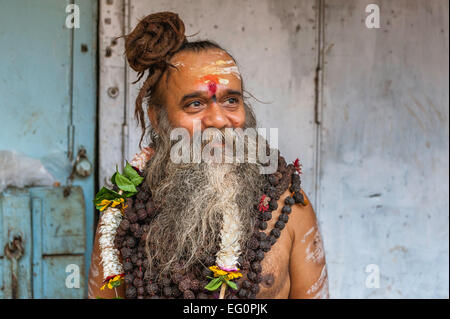 Un sadhu, Indù uomo santo, in un pellegrinaggio che indossa la faccia delle marcature e collane. Foto Stock