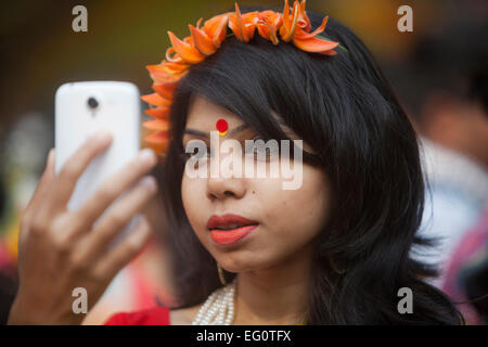 Dacca in Bangladesh. Il 13 febbraio, 2015. Ragazza del Bangladesh tenendo selfi durante il 'Basanta Utsab' o Festival di Primavera di Dhaka. Centinaia di persone riunite nella cultura della cerimonia di benvenuto il primo giorno di 'Basanta", che è noto come il simbolo della vita e inizia con il primo giorno del mese in bengali del credito Phalgun: zakir hossain chowdhury zakir/Alamy Live News Foto Stock