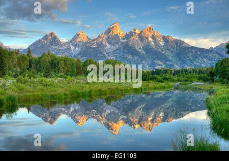 Fantastico sunrise nel Grand Teton Mountains riflessa su di un tranquillo laghetto di diramazione della Snake River. Specchio di riflessione ancora, dipinto di sky, foresta. Foto Stock