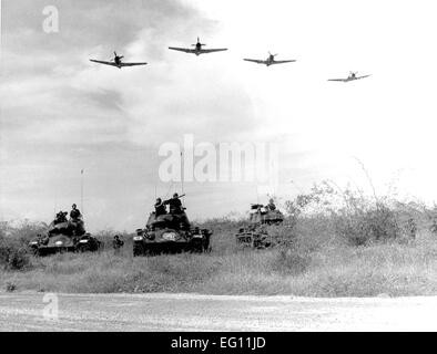 Anni sessanta -- una formazione di un-1H Skyraider singolo attacco sedile aereo fa un basso livello di passare oltre il vietnamita carri armati e le truppe a terra durante un esercizio di formazione nel Vietnam del Sud il 9 novembre 21, 1963. Il Skyraider ispirato il rettilineo-alato, slow-battenti, jet-powered successore, la A-10 Thunderbolt II attacco a terra di aeromobili. Foto Stock