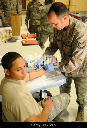 CANNON AIR FORCE BASE, N.M. -- Airman 1. Classe David docce, 27 Special Operations Support Squadron, riceve il sangue prelevato da Tech. Sgt. Michael Buongiorne, 27 Operazioni speciali Assistenza Medica Squadron, in preparazione per la distribuzione per Haiti. Circa 45 aviatori da qui pronti a sostenere il terremoto sforzi in Haiti. Senior Airman Erik Cardenas Foto Stock