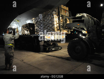 Apparecchiatura viene scaricato da un Charleston C-17 a Port-au-Prince, Haiti Gen 15, 2010. I materiali di consumo sono in un flusso continuo di aria mobilità comando per rispondere all'impegno umanitario in Haiti. U.S.Air Force foto/Senior Airman Katie Gieratz Foto Stock