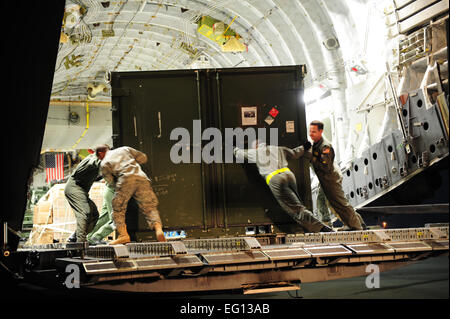 Stati Uniti Air Force aviatori cargo carico su una C-17 Globemaster III prima di una missione a sostegno del terremoto ad Haiti soccorsi a Langley Air Force Base, Va., gen. 16, 2010. Il velivolo, dal 452nd Aria Mobilità ala, marzo riserva d'aria di base, California, sta portando aiuti umanitari insieme con gli Stati Uniti I soldati dell esercito e delle attrezzature dal 688th rapida apertura porta elemento, Fort Eustis, Va. Staff Sgt. Giacobbe N. Bailey Foto Stock