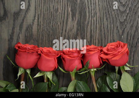 Sfondo romantico con rose rosse sul tavolo di legno Foto Stock