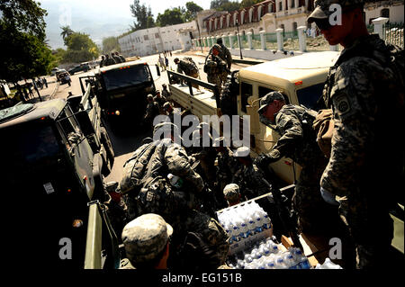 Stati Uniti I soldati dell esercito con Bravo Company, 2° Battaglione, 325Airborne Reggimento di Fanteria, 2° Brigata Team di combattimento, ottantaduesima Airborne Division, Fort Bragg, NC, out invece il terremoto di cibo e di acqua alla locale haitiani a gennaio 22, 2010 a Port-au-Prince, Haiti per funzionamento risposta unitaria. I soldati consegnati 300 umanitario razioni giornaliere e 600 bottiglie di acqua in questo viaggio. Un devastante terremoto ha colpito la regione il 12 gennaio 2010. Master Sgt. Jeremy bloccare rilasciato Foto Stock