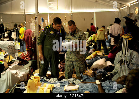 Stati Uniti Air Force Chief, medicina interna il colonnello Len Profenna, USAFSAM e chirurgo generale principali Nathan Piovesan, 96SGOS, Eglin AFB, FL, schermo terremoto pazienti presso la University of Miami medical tende a Toussaint Louverture Aeroporto Internazionale di Port-au-Prince, Haiti il 25 gennaio 2010 durante il funzionamento risposta unitaria. I medici sono di screening 27 pazienti per essere evacuata dal punto di vista medico sulla C-17 per l'Aeroporto Internazionale di Miami e a Fort Lauderdale, FL. Dipartimento della Difesa sono state distribuite per assistere in Haiti soccorsi a seguito di un ordine di grandezza 7 il terremoto che ha colpito il th Foto Stock