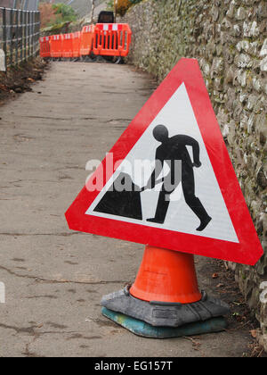 Gli uomini al lavoro sign in una piccola strada in Cumbria Foto Stock