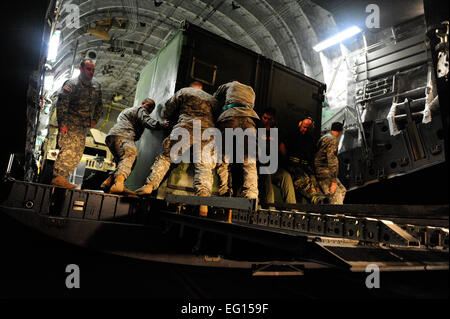 Un U.S. Air Force C-17 Globemaster III equipaggio dal ventunesimo Airlift Squadron, Travis Air Force Base in California, fuori carico U.S. Il materiale dell'esercito da Fort Bragg, N.C., con l aiuto di aviatori e soldati provenienti da varie unità a Toussaint Louverture Aeroporto Internazionale di Port-au-Prince, Haiti, a sostegno del terremoto di Haiti gli sforzi di rilievo. Il personale Sgt. Joshua L. DeMotts Non rivisto Foto Stock