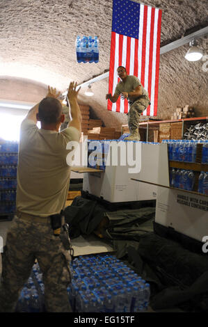 Army Sgt. Anthony Hopkins sinistra lanci un pacco di acqua a Spc. Patrick Vinzani per essere caricata su di un pallet in una non divulgato Asia sud-ovest posizione il 19 maggio 2010. Entrambi i soldati sono 824th Quartermaster Company, det. 9, parachute riggers. La 824 QM CO prepara palette di alimentazione e paracaduti per air drop le consegne in Iraq e in Afghanistan. Senior Airman Kasey Zickmund[] Foto Stock