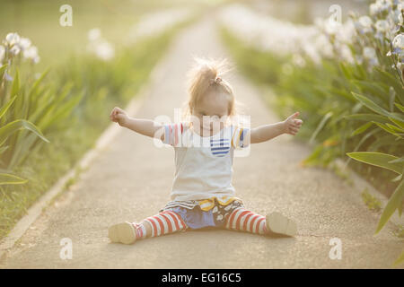 Funny Girl con la sindrome di Down in seduta il sole al tramonto Foto Stock