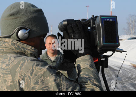 RAMSTEIN AIR BASE, Germania -- STATI UNITI Air Force Staff Sgt. Tiffany Gordon, un emittente con forze americane Rete Europa, controlli la sua fotocamera impostazioni dal 4 dicembre 2010, a Ramstein Air Base, Germania, mentre intervistando U.S. Esercito il Mag. Tim McDonald, U.S. Comando europeo Direttore Logistica, circa la risposta di incendi nei pressi di Haifa, Israele. Stati Uniti Forze aeree in Europa ha cominciato airlifting 20 tonnellate di ritardante del fuoco in uno sforzo congiunto per fornire assistenza umanitaria nella lotta contro il peggiore di incendi nella storia d Israele. Stati Uniti Comando europeo ha acquistato il ritardante di fiamma e iniziò la missione seguente Foto Stock