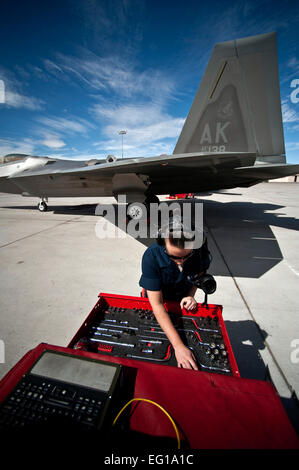 Stati Uniti Air Force Senior Airman Samantha Whisman guarda oltre i suoi strumenti prima di preparare una Forza Aerea F-22 Raptor Fighter Aircraft per una missione di addestramento il 2 marzo 2011, durante una bandiera rossa esercizio presso la Base Aerea Militare di Nellis Nev. Whisman è un capo equipaggio assegnati al novantesimo Manutenzione aeromobili squadrone a Elmendorf Air Force Base in Alaska. Tech. Sgt. Michael R. Holzworth Foto Stock