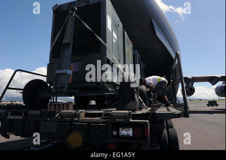 Un 735th aria mobilità rampa squadrone tecnico di assistenza generatori di carichi su un U.S. Air Force C-17 Globemaster III cargo aereo a base comune Harbor-Hickam perla, Hawaii, in preparazione per la sua partenza per una missione umanitaria in Giappone il 12 marzo 2011. Il velivolo si recherà a varie forze aeree basi in Giappone durante la sua missione di fornire il supporto per gli interventi di soccorso in scia di tsunami e danni del terremoto in Giappone. Il personale Sgt. Nathan Allen Foto Stock