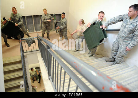 Avieri frequentando Airman Leadership School presso Aviano Air Force Base, Italia, spostare le culle in un dormitorio per chiamate in entrata servicemembers distribuito come supporto di Joint Task Force Odissea all alba del 21 marzo 2011. Joint Task Force Odyssey Dawn è la U.S. Africa il comando task force istituita per sostenere la più grande risposta internazionale ai disordini in Libia. Una vasta coalizione di nazioni stanno collaborando per applicare U.N. Risoluzione del Consiglio di sicurezza della risoluzione UNSCR 1973, che autorizza tutti i mezzi necessari per proteggere i civili in Libia sotto la minaccia di attacco da parte del regime di Gheddafi forze. JTF Odyssey Dawn è comandato da Admi Foto Stock