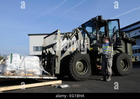 Stati Uniti Air Force Airman 1. Classe Mark Rapala dirige Senior Airman Zachary Davis, sia dal 86disponibilità logistica Squadron, come egli si muove un pallet a sostegno della Joint Task Force Odyssey Dawn, Ramstein Air Base, Germania, 24 marzo 2011. Joint Task Force Odyssey Dawn è la U.S. Africa il comando task force istituita per fornire comando operativo e tattico e di controllo le forze militari USA a sostegno della risposta internazionale per i disordini in Libia e in applicazione della risoluzione del Consiglio di Sicurezza delle Nazioni Unite della risoluzione UNSCR 1973. La UNSCR 1973 autorizza tutte le misure necessarie per proteggere i civili Foto Stock