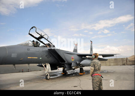 Il personale Sgt. Tamara Rhone, 455th Expeditionary Manutenzione aeromobili squadrone capo equipaggio, attende il Mag. Christine Mau, 455th aria ala Expeditionary delegato e un F-15E Strike Eagle, pilota e il cap. Jennifer Morton, 389a Expeditionary Fighter Squadron sistema di armi officer a don i loro caschi prima del decollo a Bagram Air Field, Afghanistan, Marzo 29. Membri dalla 389a EFS aiutano a rendere questa missione di combattimento per essere volato, pianificato e gestito interamente da femmine. SrA Sheila Devera Foto Stock