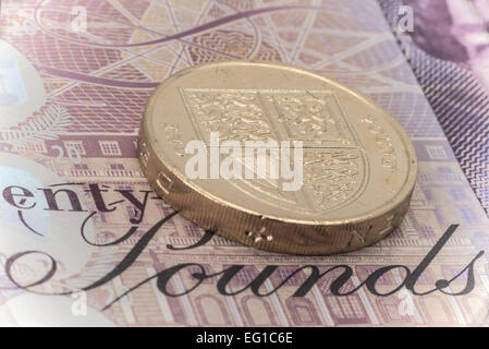 Close-up di un Regno unito a una libbra medaglia posto su una ventina di cancelletto banconota - studio shot Foto Stock