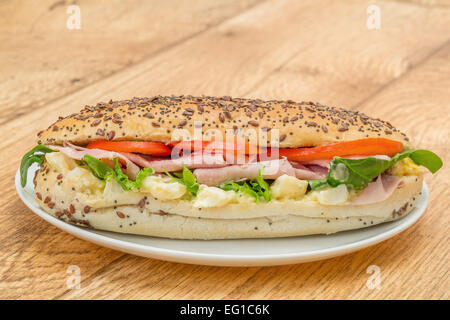Prelibato prosciutto, uova e sandwich di pomodoro servita in un panino seminate Foto Stock