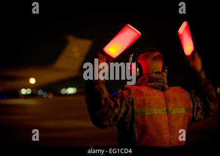 YOKOTA AIR BASE, Giappone -- una U.S. Air Force capo equipaggio esegue il marshalling di un C-5 Galaxy caring Marines e le loro attrezzature dalla risposta iniziale di forza nel proprio posto di parcheggio a Yokota Air Base, 3 aprile. Il Biologico chimica Incident Response Force è un 155-persona team composto da marines dalla base navale di meccanismo di sostegno, Indian Head, Md. Come un elemento più piccolo del chimico, biologico e incident response force, il CBIRF è specificatamente addestrato nei settori della chimica, biologica, radiologica, nucleare e ad alta resa di operazioni di esplosione. L'IRF sosterrà il funzionamento Tomodachi fornendo un rapi Foto Stock