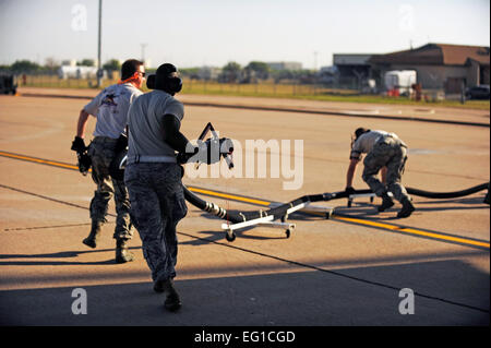 Avieri dal California Air National Guard's 146Airlift Wing, la Carolina del Nord Air National Guard's 145Airlift Wing e il Wyoming Air National Guard's 153Airlift Wing rimuovere un agente ignifugo flessibile da una forza aerea C-130H Hercules cargo aeromobili equipaggiati con il sistema modulare Airborne impianto antincendio MAFFS a Dyess Air Force Base in Texas, 19 aprile 2011. Il MAFFS è in grado di erogare 3.000 galloni di acqua o ritardante del fuoco in meno di 5 secondi. Incendi sono sparsi in varie parti del Texas e hanno bruciato più di mille chilometri quadrati di terra. Il personale Sgt. Eric Harris Foto Stock