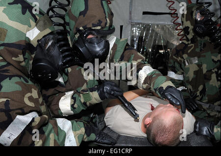 La decontaminazione ai membri del team di simulare la decontaminazione di una lettiga paziente dopo un attacco missile durante un esercizio a Misawa combatté Air Base, Giappone, 21 giugno 2011. Avieri a Misawa combatté partecipano in un giro esercizio progettata per testare la loro capacità di sopravvivere e di operare in un ambiente di combattimento. Il personale Sgt. Marie Brown Foto Stock