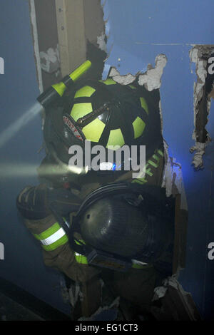 Matteo Croteau, un vigile del fuoco con il cinquantacinquesimo ingegnere civile Squadron, spreme attraverso una parete all'interno dell'Edificio 163 a Offutt Air Force Base, Neb., durante un esercizio al 22 giugno 2011. L'esercizio è parte del 2011 Fire/EMS Sicurezza, la salute e la sopravvivenza settimana sponsorizzato dalla Associazione Internazionale di Fire Chiefs e l Associazione Internazionale dei vigili del fuoco. Il tema è sopravvissuta la terra di fuoco: Fire Fighter/Fire Officer &AMP; il comando di preparazione, che rafforza la consapevolezza per le procedure appropriate quando un vigile del fuoco ha bisogno di assistenza. Charles Haymond Foto Stock