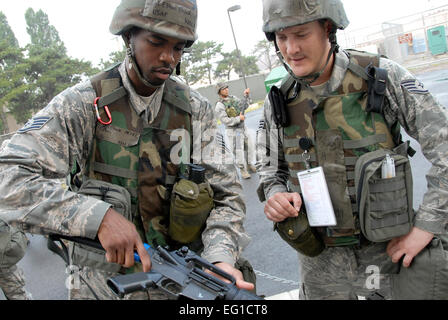 Air Force Staff Sgt. Elton Brock, sinistra, cancella la sua M-16 fucile mentre il personale Sgt. Steven Herzog offre formazione di orientamento. Entrambi gli avieri sono assegnati al cinquantunesimo ingegnere civile Squadron, Osan Air Base, Repubblica di Corea. Circa 150 aviatori dalla 51st ingegnere civile Squadron ha partecipato in Prime Carni bovine allenamento Giugno 22, 2011. Senior Master Sgt. Paolo Holcomb Foto Stock