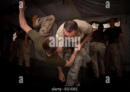 Un aviatore spalla getta una marina durante il Marine Corps Arti Marziali MCMAP della formazione di Camp Leatherneck nella provincia di Helmand in Afghanistan su agosto 30, 2011. Mediante la combinazione di tecniche di combattimento con formazione di endurance, il servizio i membri saranno in grado di migliorare la loro forma fisica e di ampliare le loro conoscenze di MCMAP. dai Sottufficiali di seconda classe Jonathan Chandler Foto Stock