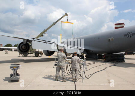 Due Stati Uniti Air Force aviatori monitorare un regolatore di pressione dell'aria come una gru si prepara a sollevare il naso di una Forza Aerea KC-135 Stratotanker antenna aerei di rifornimento durante un esercizio il Agosto 13, 2011, a Selfridge Air National Guard Base, Mich. La 191st squadrone di manutenzione eseguito un esercizio dove è stato simulato un KC-135 Stratotanker aveva danneggiato naso ingranaggio e una gru è stata necessaria per spostare il velivolo in una posizione sicura per la riparazione. In corrispondenza della coda del velivolo una serie di aria gonfiata le vesciche sono state utilizzate per aiutare a sostenere il velivolo durante l'operazione. Tech. Sgt. Daniel Heaton Foto Stock