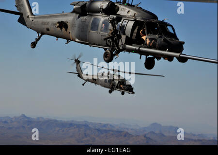 Due Stati Uniti Air Force HH-60 Pave Hawk elicotteri da 66 Rescue Squadron manovra dietro un HC-130 re aeromobili per eseguire un elicottero air refuelling a Davis-Monthan Air Force Base in Arizona ott. 16, 2011, durante l'angelo Thunder 2011. Angelo Thunder è un combattimento aereo comando-sponsorizzato personale di recupero/combattere la ricerca e il salvataggio di esercizio che combina il Dipartimento della Difesa DoD e non-DoD asset. Il personale Sgt. Andy M. Kin Foto Stock