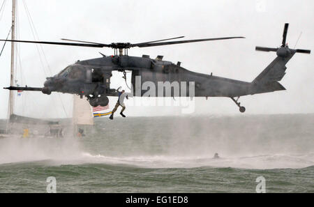 Stati Uniti Air Force aviatori dal 920th ala di salvataggio RQW eseguire un salvataggio dell'acqua dimostrazione usando una forza aerea HH-60G Pave Hawk elicottero durante la Cocoa Beach Air Show 2011 in Cocoa Beach, Florida, nov. 5, 2011. Il 920th RQW ha celebrato 50 anni di manned space il supporto che serve come guardiani degli astronauti. Il personale. Sgt. Anna-Marie Wyant. Foto Stock