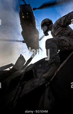 Stati Uniti Air Force Staff Sgt. Ian Zerby assegnato alla 820th cavallo rosso squadrone airborne volo si prepara a rig una connex box per una imbragatura-carico come un esercito nazionale Guard CH-47 elicottero Chinook aleggia il sovraccarico durante un tempo di pace il funzionamento nov. 9, 2011, in Alamo, Nev. L'imbracatura-formazione di carico e air assault certificazione di 820th RHS airborne flight aviatori si è rivelata cruciale per il successo della risposta rapida operazione. Airman 1. Classe Daniel Hughes Foto Stock